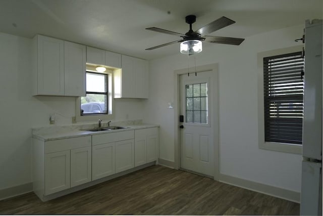 315 W Greenwood Ave, Aransas Pass, TX 78336 - kitchen with light countertops, a sink, white cabinetry, and dark wood finished floors