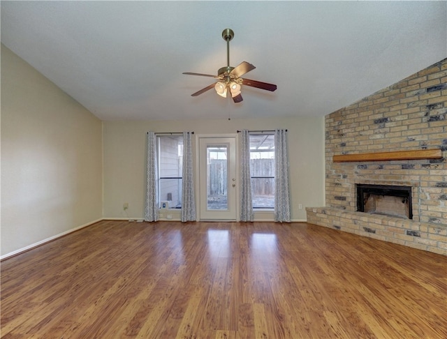 unfurnished living room featuring a fireplace, hardwood / wood-style flooring, ceiling fan, and lofted ceiling