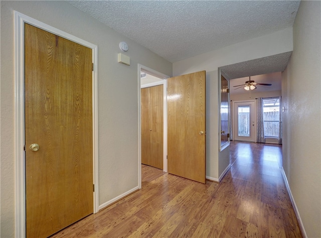 hall featuring wood-type flooring and a textured ceiling