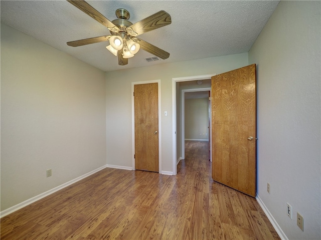 unfurnished bedroom featuring ceiling fan, light hardwood / wood-style floors, and a textured ceiling