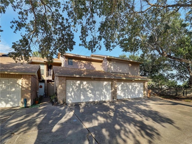 7140 Premont Dr Unit 12, Corpus Christi, TX 78414 - view of front of property featuring concrete driveway, a garage, brick siding, and fence