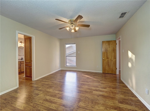 unfurnished room with a textured ceiling, ceiling fan, and dark hardwood / wood-style floors