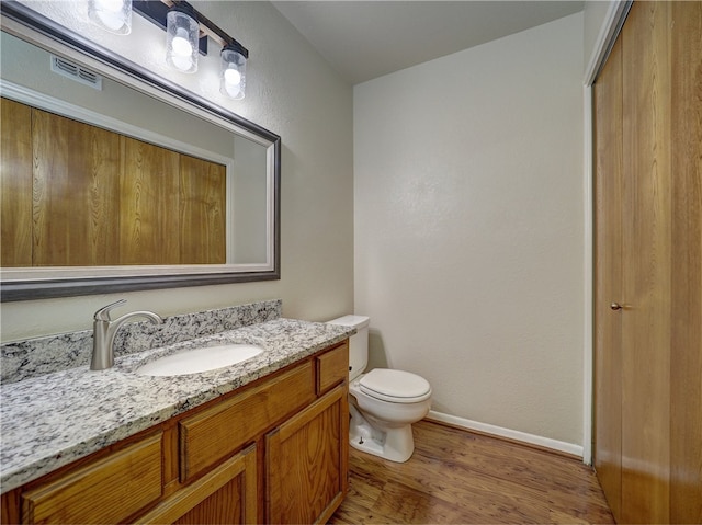 bathroom featuring hardwood / wood-style floors, vanity, and toilet