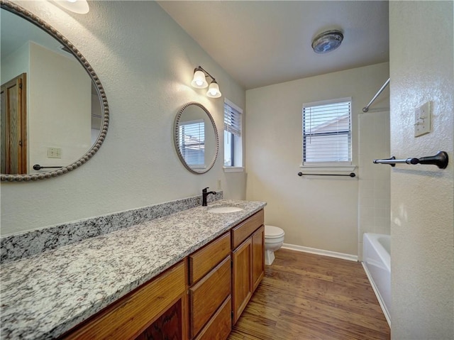7140 Premont Dr Unit 12, Corpus Christi, TX 78414 - full bath with wood finished floors, toilet, baseboards, vanity, and  shower combination