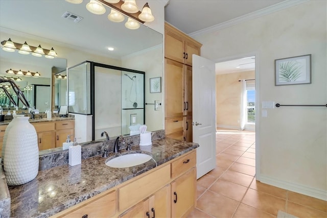 bathroom with tile patterned floors, vanity, a shower with door, and ornamental molding