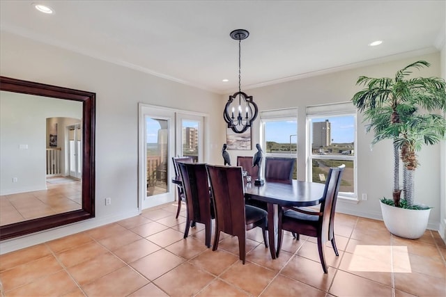 tiled dining area featuring a notable chandelier, plenty of natural light, and crown molding