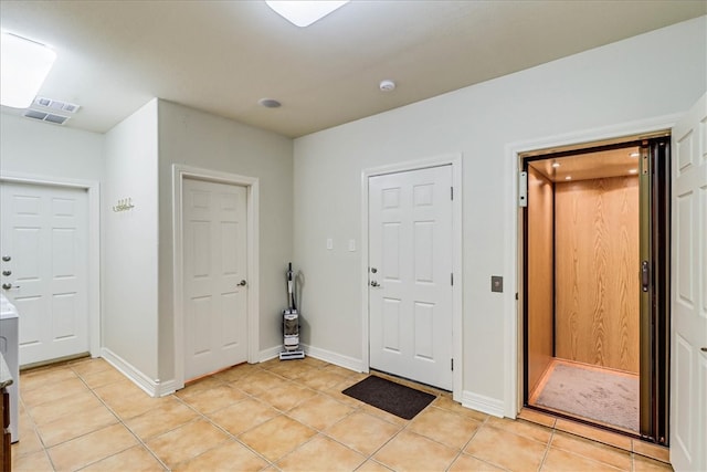 tiled foyer entrance featuring elevator