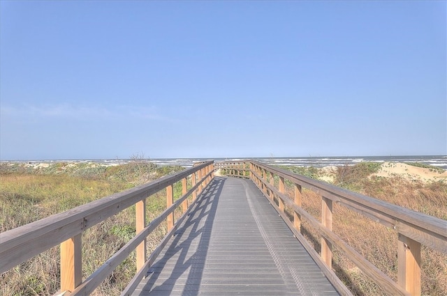 view of community featuring a water view and a beach view