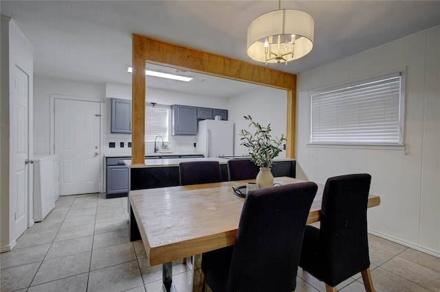 tiled dining area featuring sink and an inviting chandelier