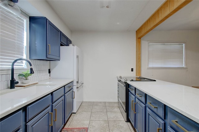 kitchen with sink, light tile patterned floors, backsplash, stainless steel electric stove, and blue cabinetry