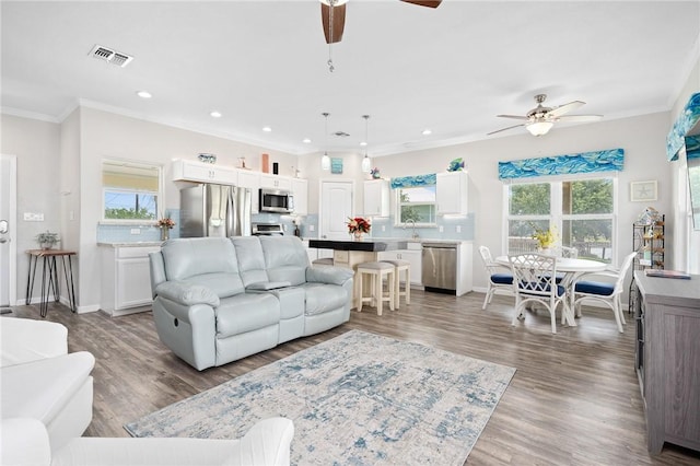 219 Pintail Ln, Rockport, TX 78382 - living room with ceiling fan, crown molding, wood finished floors, recessed lighting, and baseboards
