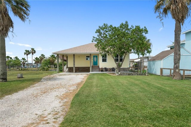 219 Pintail Ln, Rockport, TX 78382 - rear view of house with driveway, a yard, a carport, and roof with shingles