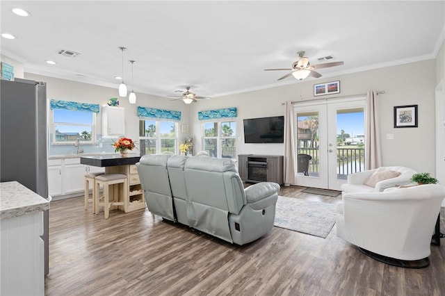 219 Pintail Ln, Rockport, TX 78382 - living area with healthy amount of natural light, wood finished floors, recessed lighting, crown molding, and a ceiling fan