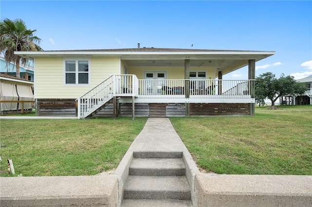 219 Pintail Ln, Rockport, TX 78382 - view of front facade featuring stairway, a front yard, and covered porch