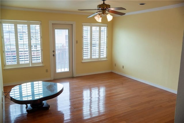 doorway to outside featuring ceiling fan, wood finished floors, baseboards, and ornamental molding