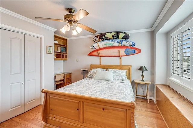 bedroom with a closet, a ceiling fan, crown molding, and light wood-style floors