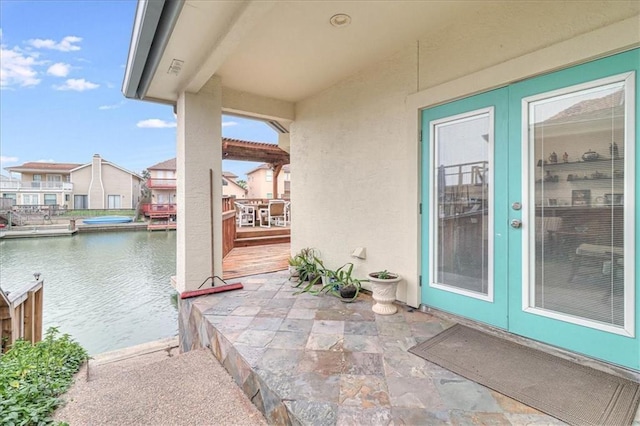 exterior space featuring a patio, a water view, and stucco siding