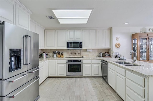 kitchen with a sink, tasteful backsplash, visible vents, and stainless steel appliances