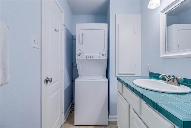 bathroom featuring stacked washer and clothes dryer and vanity