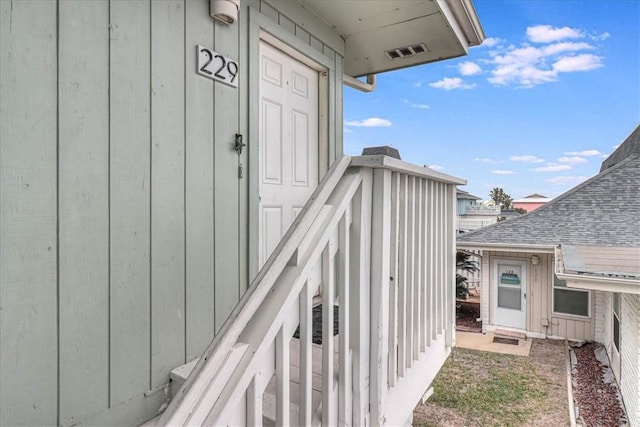 view of exterior entry with board and batten siding and visible vents