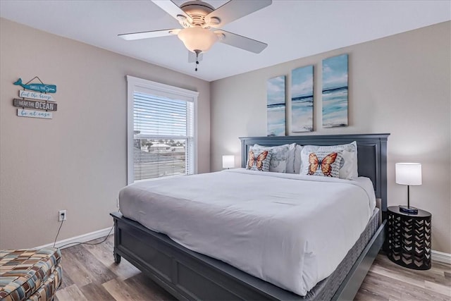 bedroom featuring ceiling fan, light wood-style flooring, and baseboards