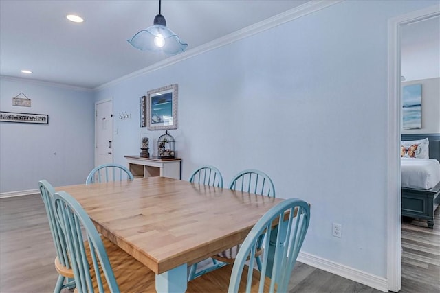 dining area with baseboards, ornamental molding, wood finished floors, and recessed lighting