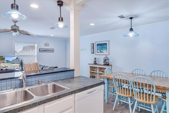 kitchen featuring dark countertops, visible vents, white cabinets, white dishwasher, and a sink