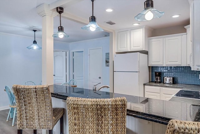 kitchen featuring ornamental molding, white cabinetry, freestanding refrigerator, and tasteful backsplash