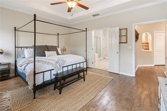 6105 Greenough Ct, Corpus Christi, TX 78414 - bedroom with crown molding, wood finished floors, a tray ceiling, connected bathroom, and ceiling fan