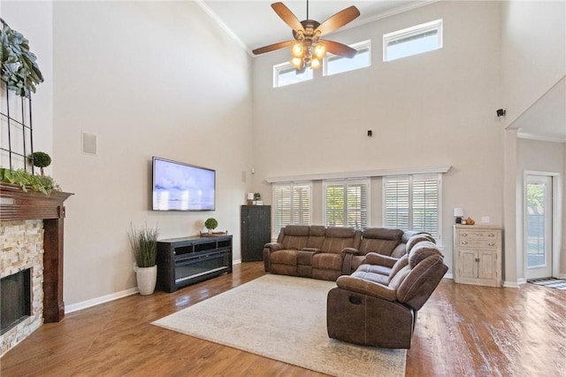 6105 Greenough Ct, Corpus Christi, TX 78414 - living area featuring a towering ceiling, crown molding, ceiling fan, wood finished floors, and a stone fireplace
