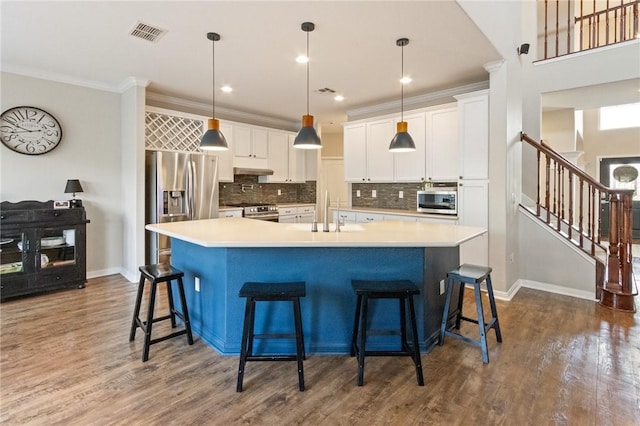 6105 Greenough Ct, Corpus Christi, TX 78414 - kitchen with appliances with stainless steel finishes, dark wood-type flooring, decorative backsplash, a large island with sink, and white cabinets