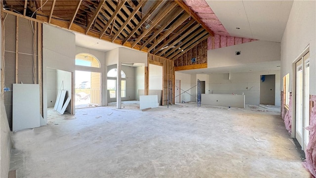 interior space with high vaulted ceiling and concrete floors