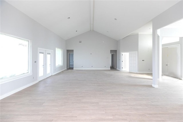 unfurnished living room with light hardwood / wood-style floors and high vaulted ceiling