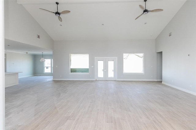 unfurnished living room with plenty of natural light, high vaulted ceiling, and light hardwood / wood-style floors