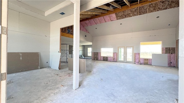 miscellaneous room with french doors, concrete floors, and lofted ceiling