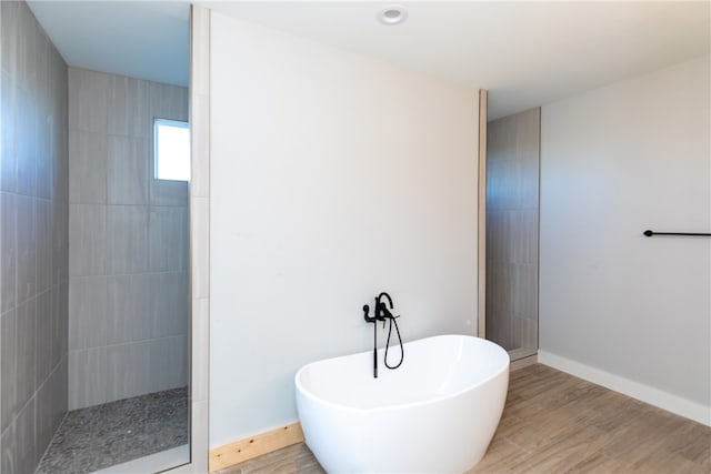 bathroom featuring plus walk in shower and hardwood / wood-style floors