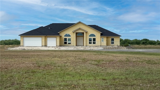 view of front of house featuring a front lawn and a garage