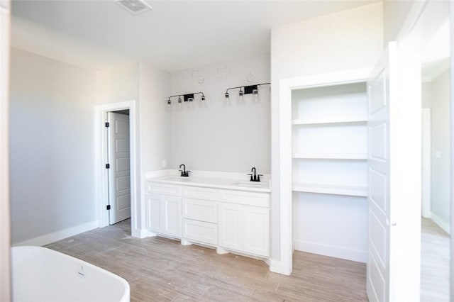 bathroom featuring wood-type flooring, vanity, and a bathtub