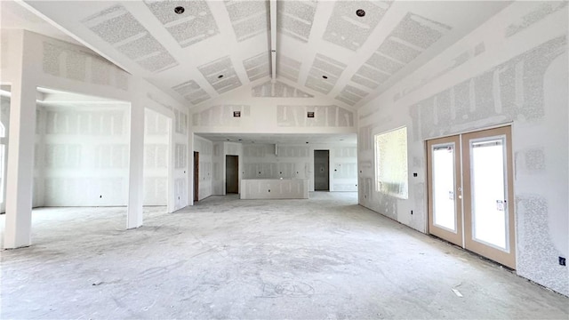 unfurnished living room with high vaulted ceiling