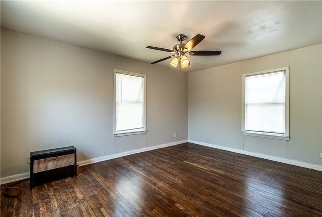 spare room with ceiling fan, dark hardwood / wood-style floors, and plenty of natural light