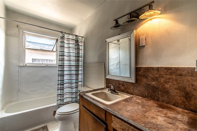 full bathroom featuring vanity, shower / bath combo, tile walls, and toilet