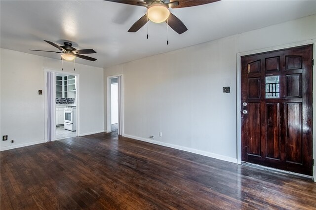 unfurnished living room with dark wood-type flooring and ceiling fan