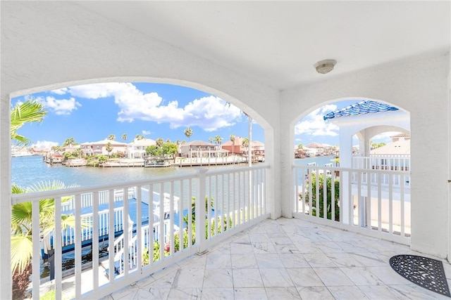 view of patio / terrace featuring a water view and a balcony