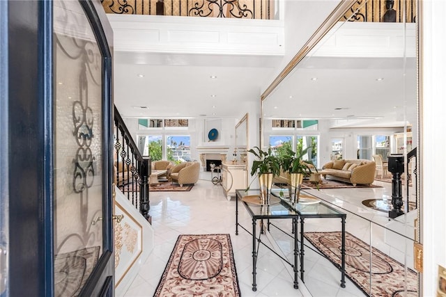 entryway with light tile patterned floors, a fireplace, and stairs