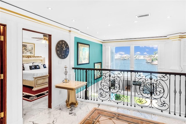 interior space with visible vents, crown molding, a water view, recessed lighting, and marble finish floor