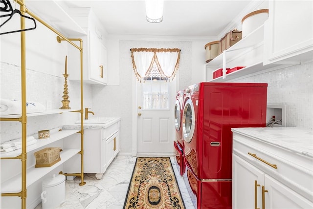 laundry room with washing machine and clothes dryer, crown molding, cabinet space, marble finish floor, and a sink