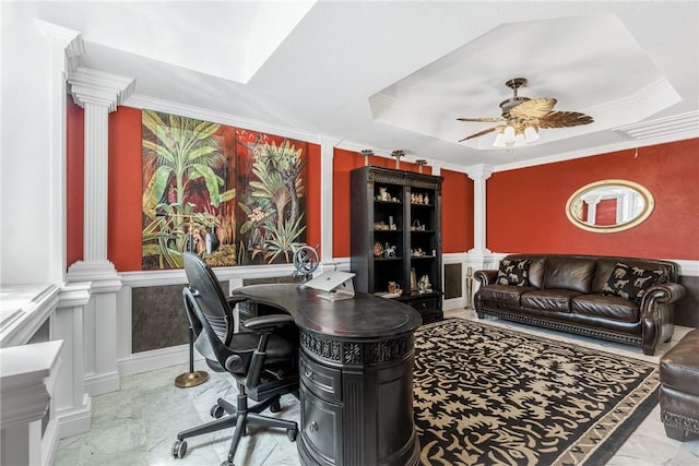 office space with wainscoting, a raised ceiling, and ornate columns