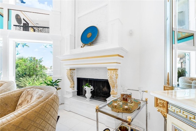 living area featuring a high ceiling and a premium fireplace