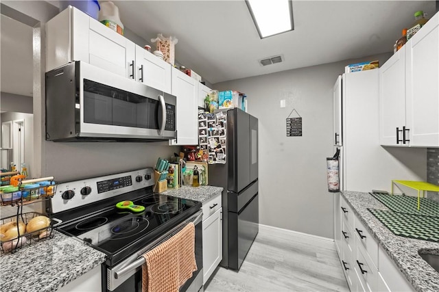 3614 Capri Dr, Corpus Christi, TX 78415 - kitchen with appliances with stainless steel finishes, light wood-style flooring, white cabinets, and light stone counters