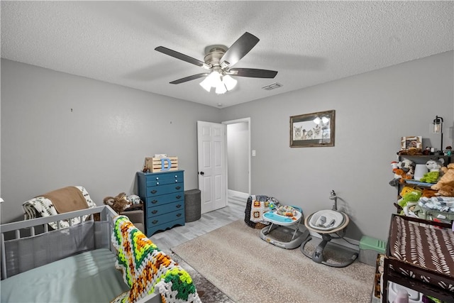 3614 Capri Dr, Corpus Christi, TX 78415 - bedroom with light wood-style floors, ceiling fan, and a textured ceiling